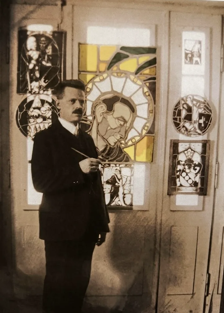 Emil Dold mit Pinsel vor bemalten Glasscheiben, sepiafarbene Fotografie
